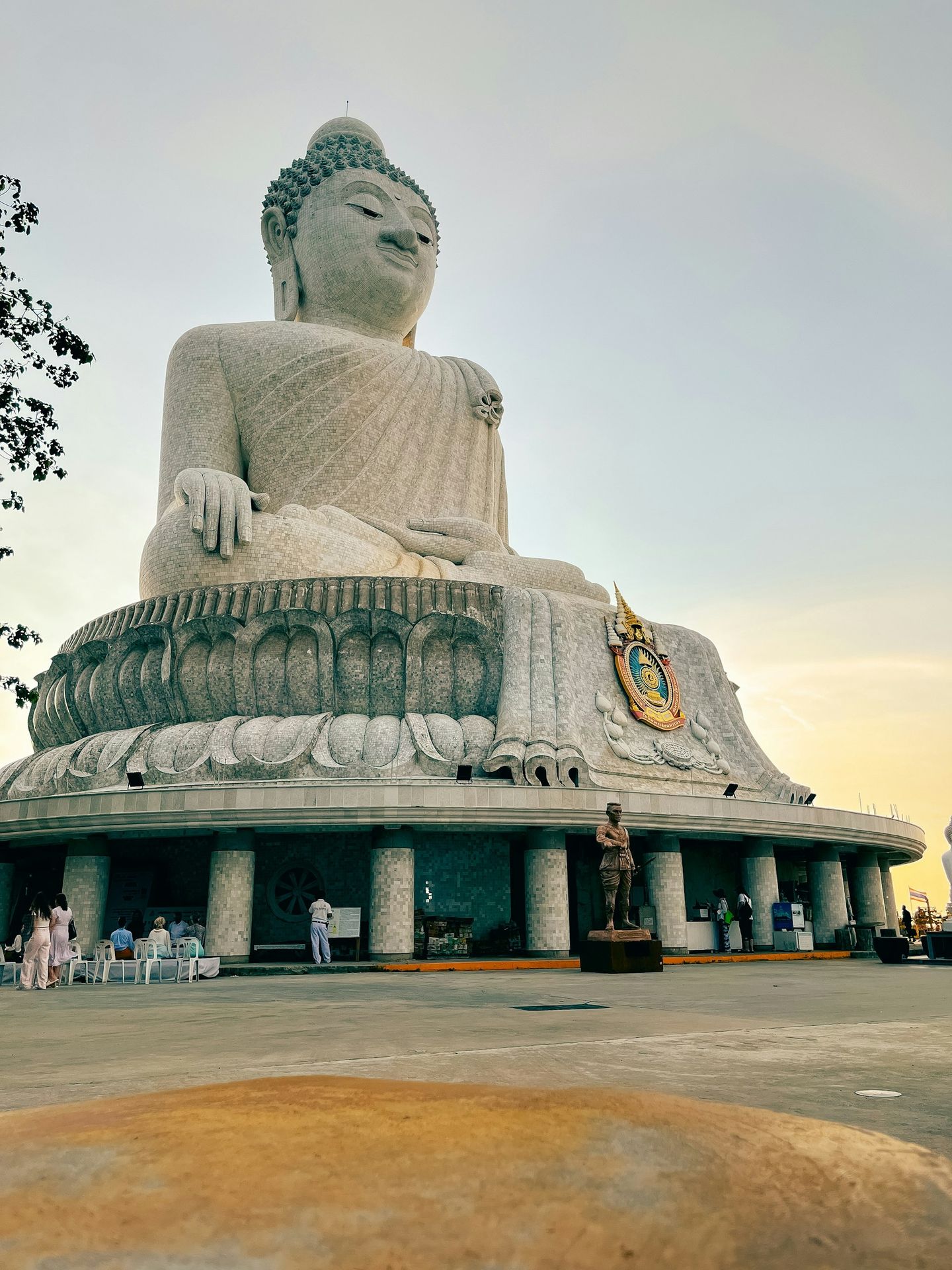 a large buddha statue sitting in the middle of a park